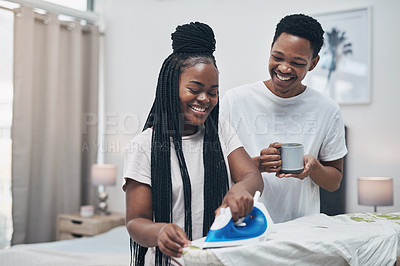 Buy stock photo Shot of a happy young couple ironing freshly washed laundry together at home