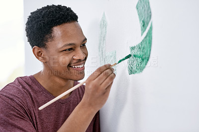 Buy stock photo Shot of a young man painting a recycle symbol on a wall