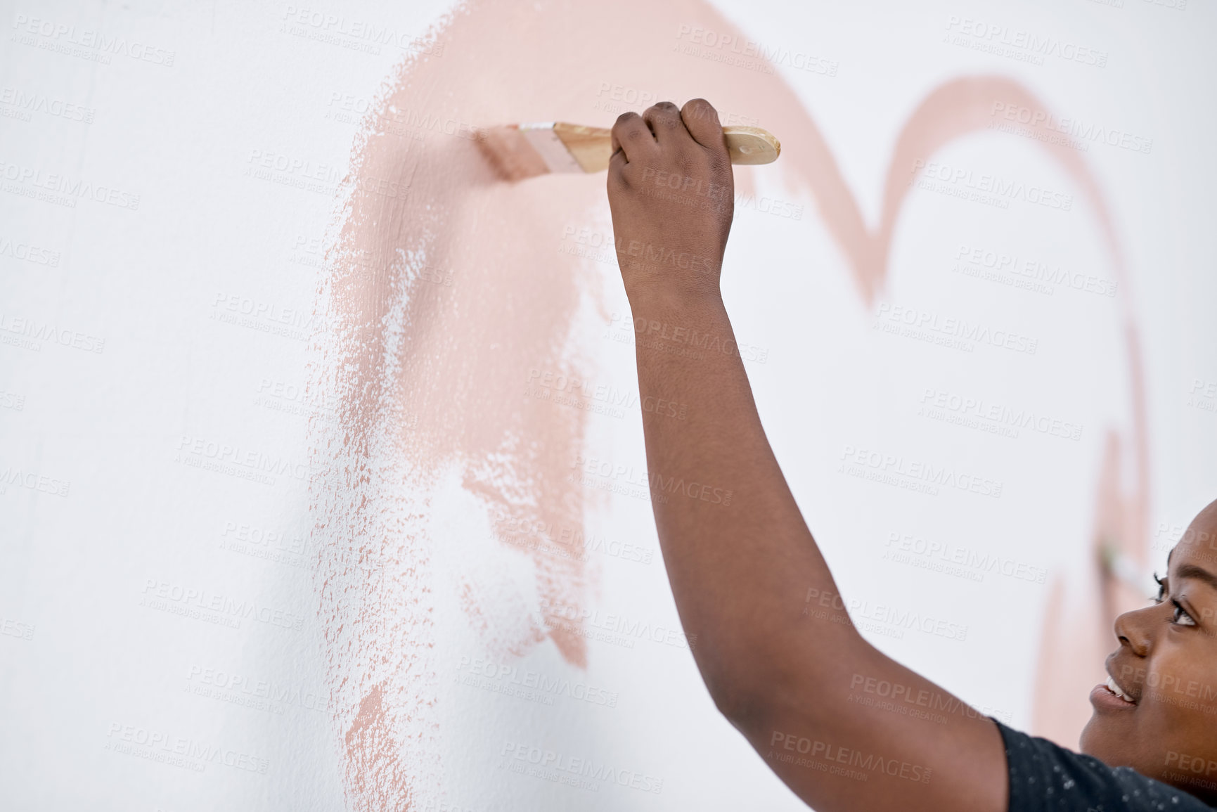 Buy stock photo Shot of a young woman painting a heart on a wall