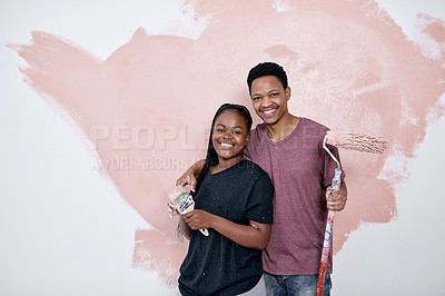 Buy stock photo Shot of a young couple painting a wall pink