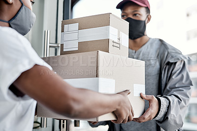 Buy stock photo Shot of a masked young man delivering a package to a customer at home