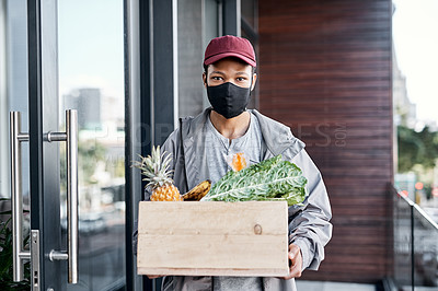 Buy stock photo Shot of a young man delivering fresh produce to a place of residence