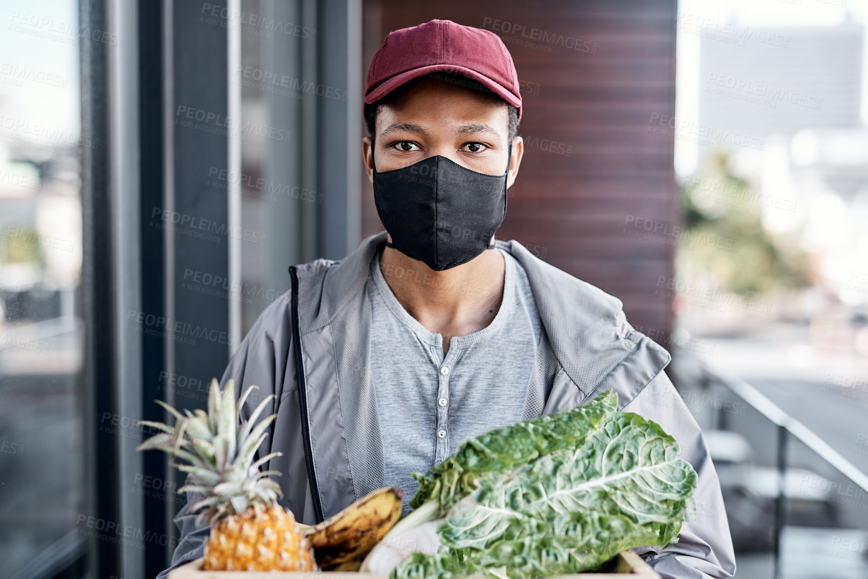 Buy stock photo Shot of a young man delivering fresh produce to a place of residence