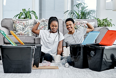 Buy stock photo Shot of a young couple recycling their trash at home