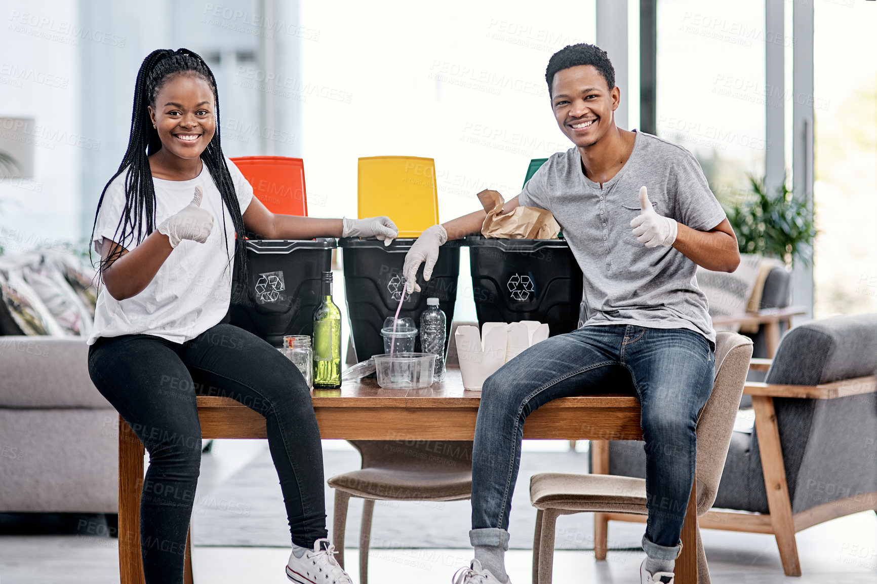 Buy stock photo Shot of a young couple recycling their trash at home