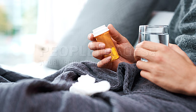 Buy stock photo Shot of an unrecognisable man taking medication while recovering from an illness in bed at home