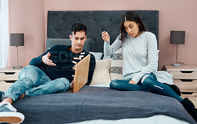 Buy stock photo Shot of a young couple looking angry while playing a game of chess at home