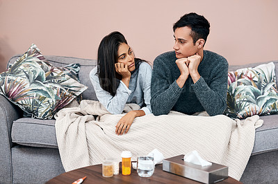 Buy stock photo Shot of a young couple sitting on the sofa while recovering from an illness at home