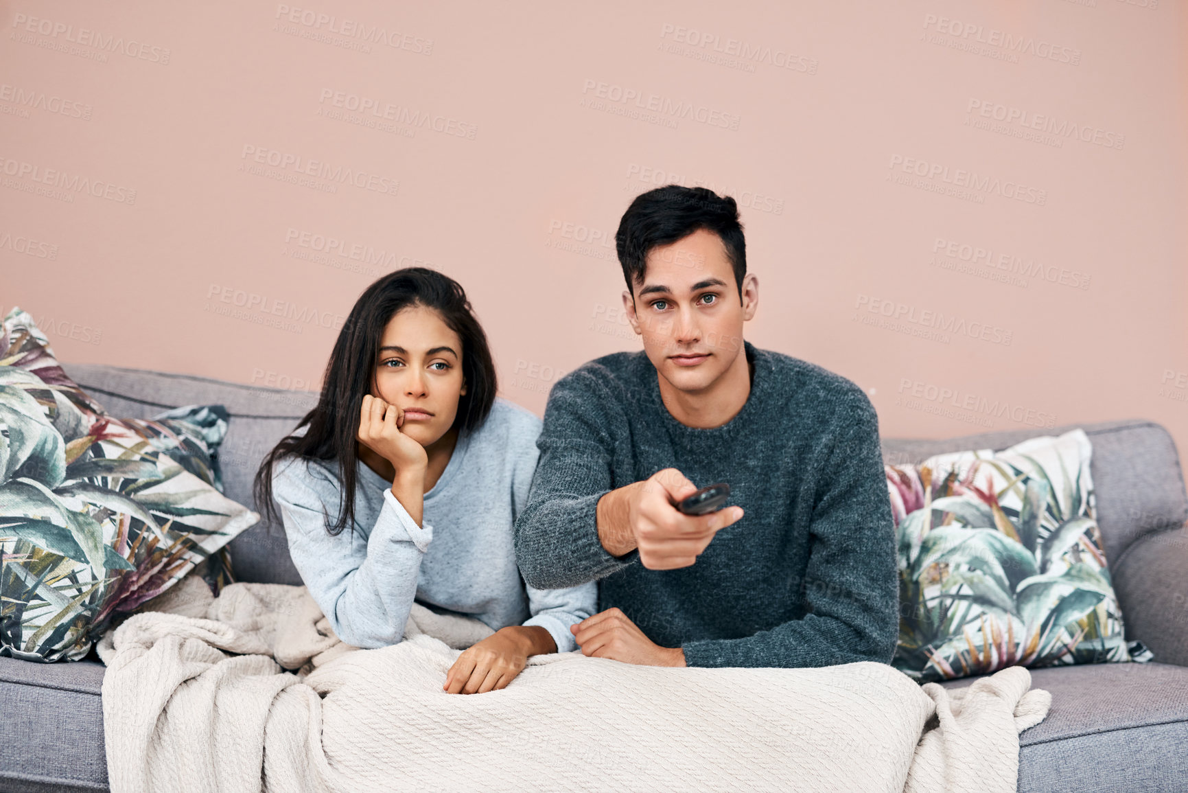 Buy stock photo Shot of a young couple watching tv while recovering from an illness at home
