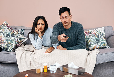 Buy stock photo Shot of a young couple watching tv while recovering from an illness at home