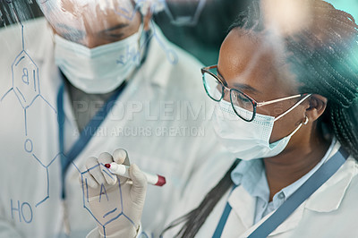 Buy stock photo Shot of two scientists drawing molecular structures on a glass wall in a lab