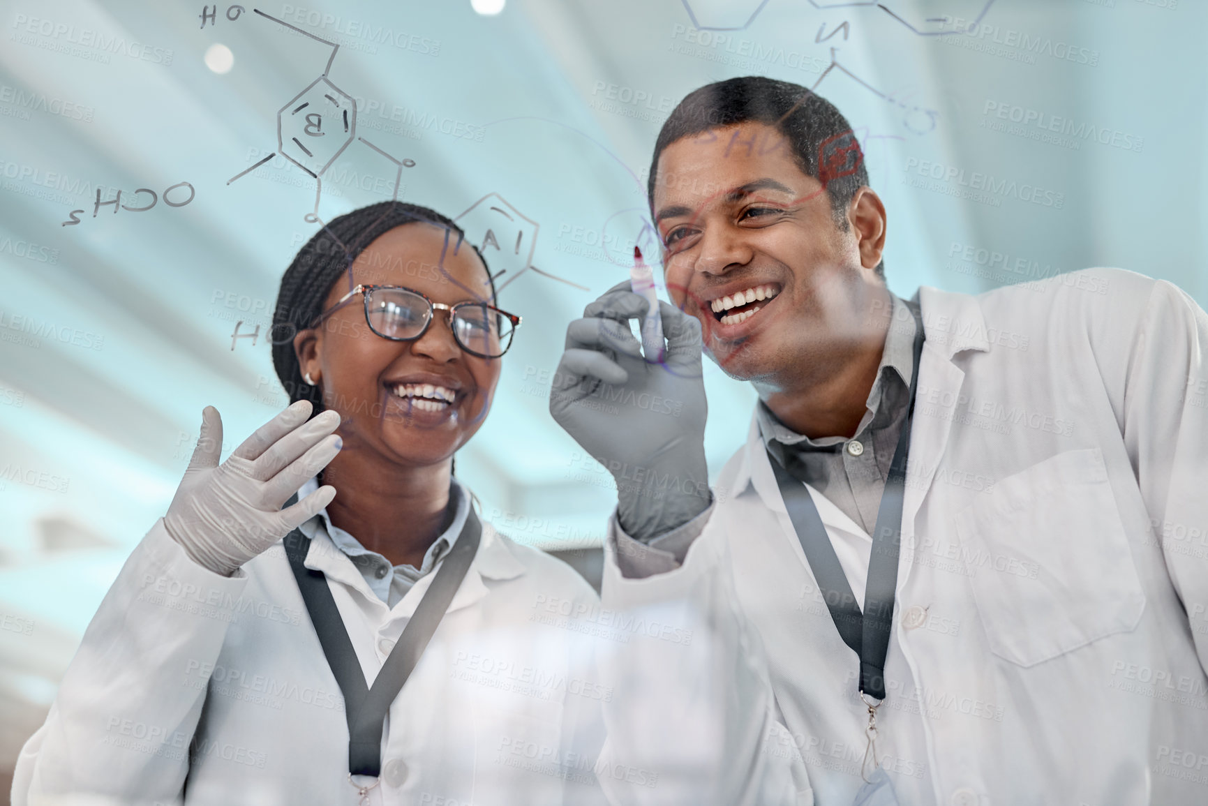 Buy stock photo Shot of two scientists drawing molecular structures on a glass wall in a lab