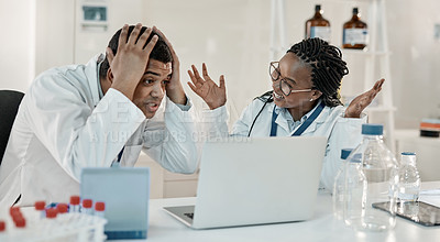 Buy stock photo Shot of two scientists looking surprised while working together on a laptop in a lab