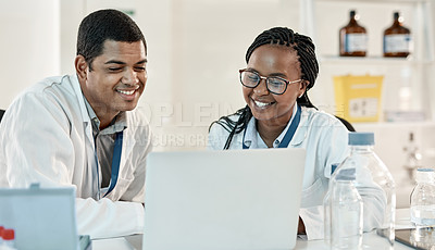 Buy stock photo Shot of two scientists working together on a laptop in a lab