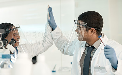 Buy stock photo Shot of two scientists giving each other a high five while working together in a lab