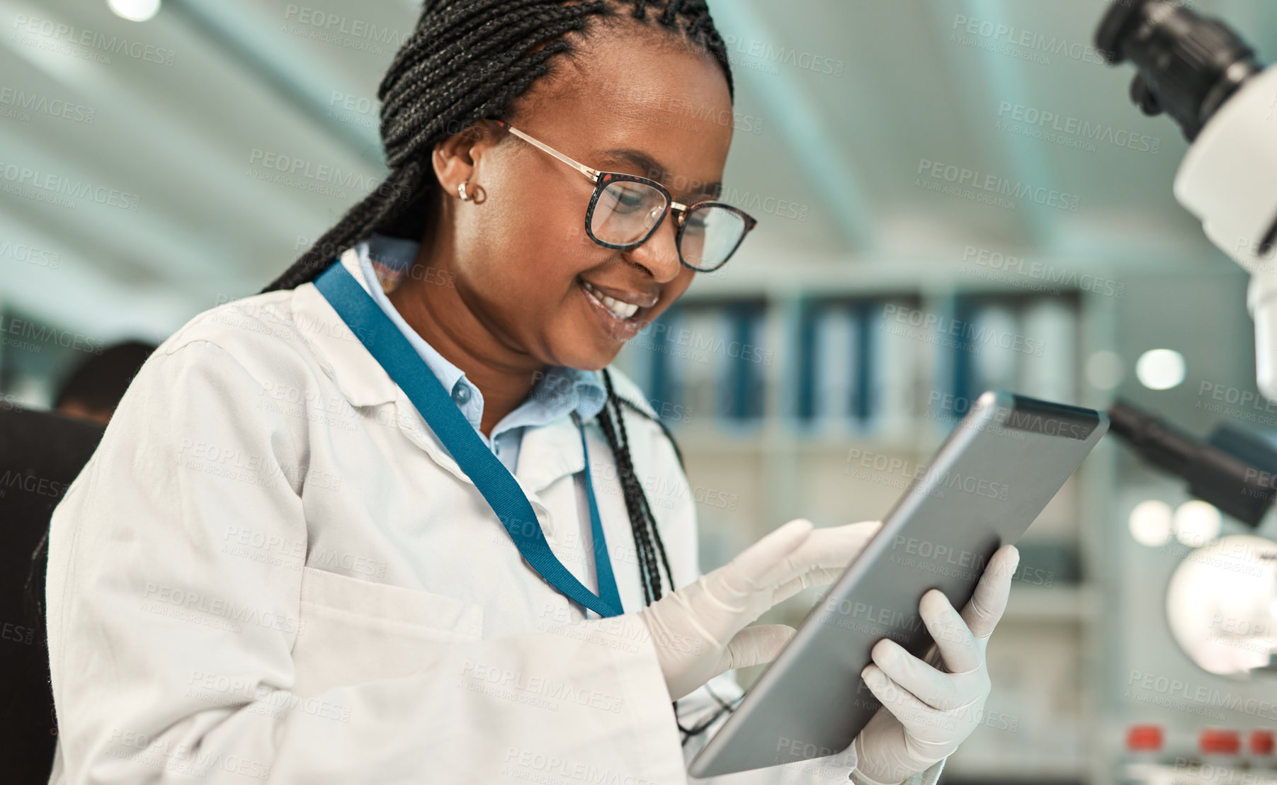 Buy stock photo Shot of a young scientist using a digital tablet in a lab