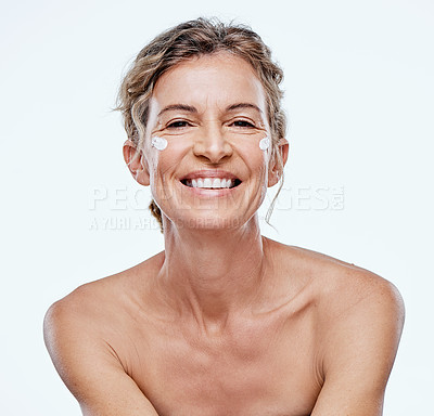 Buy stock photo Shot of a mature woman posing with moisturiser on her face