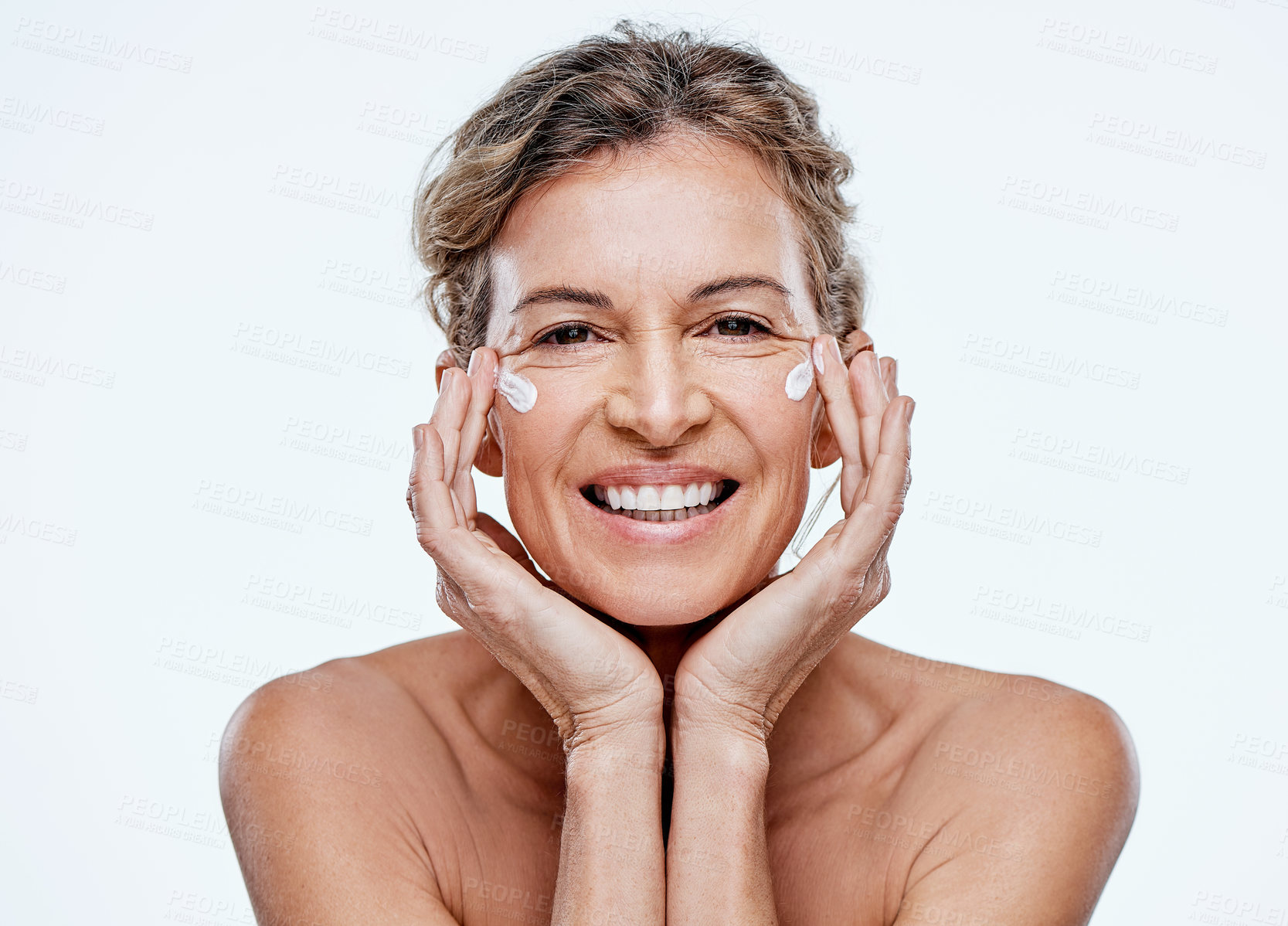 Buy stock photo Shot of a mature woman posing with moisturiser on her face