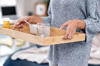 Buy stock photo Shot of an unrecognisable woman serving breakfast in bed while to someone recovering from an illness at home
