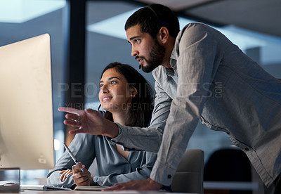 Buy stock photo Shot of a young man helping his colleague in a call centre late at night