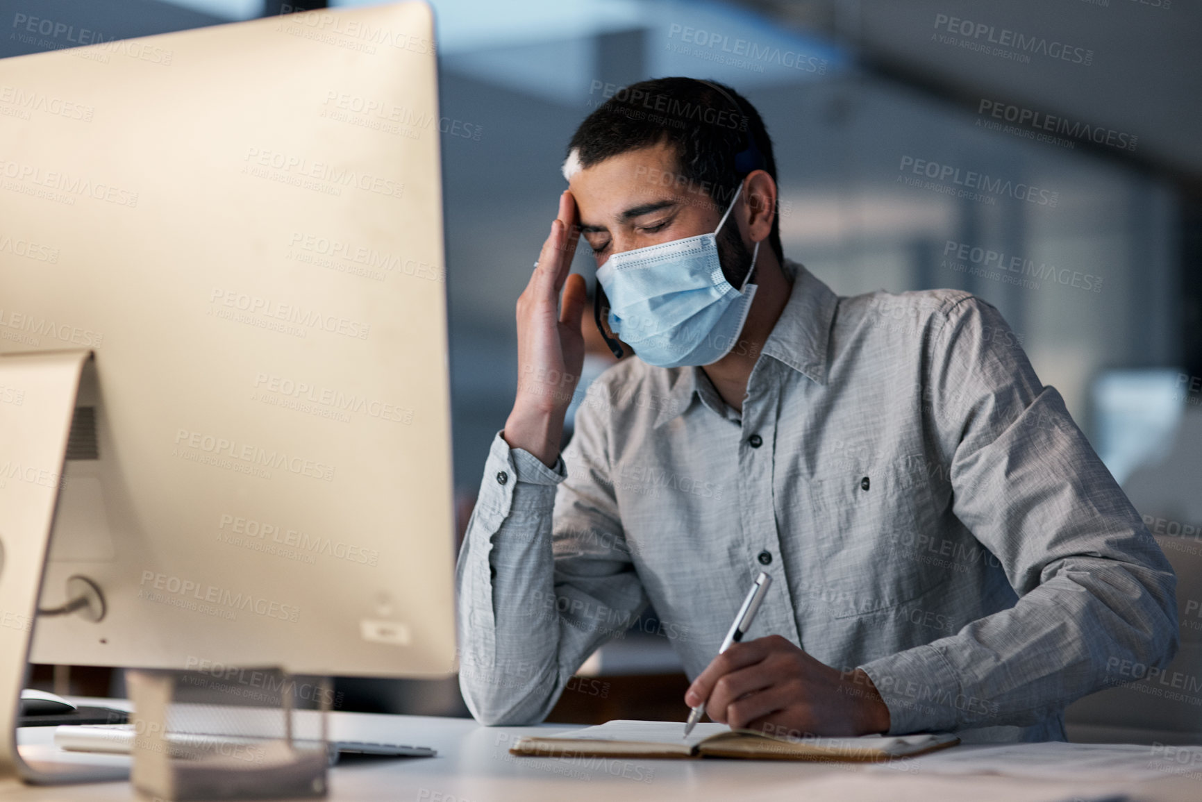 Buy stock photo Call center, man and headache with face mask at computer for stress, burnout or problem with client communication. Tired telemarketing consultant with virus protection for crisis, bad service or pain