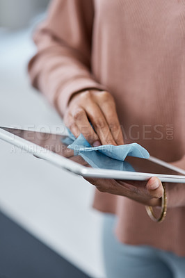 Buy stock photo Shot of an unrecognisable woman disinfecting her digital tablet while working from home