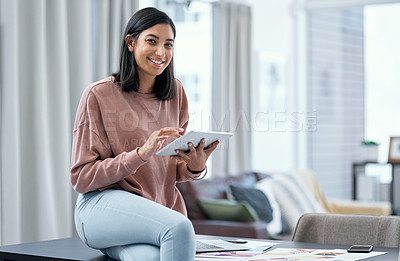 Buy stock photo Portrait of a confident young woman using a digital tablet while working from home