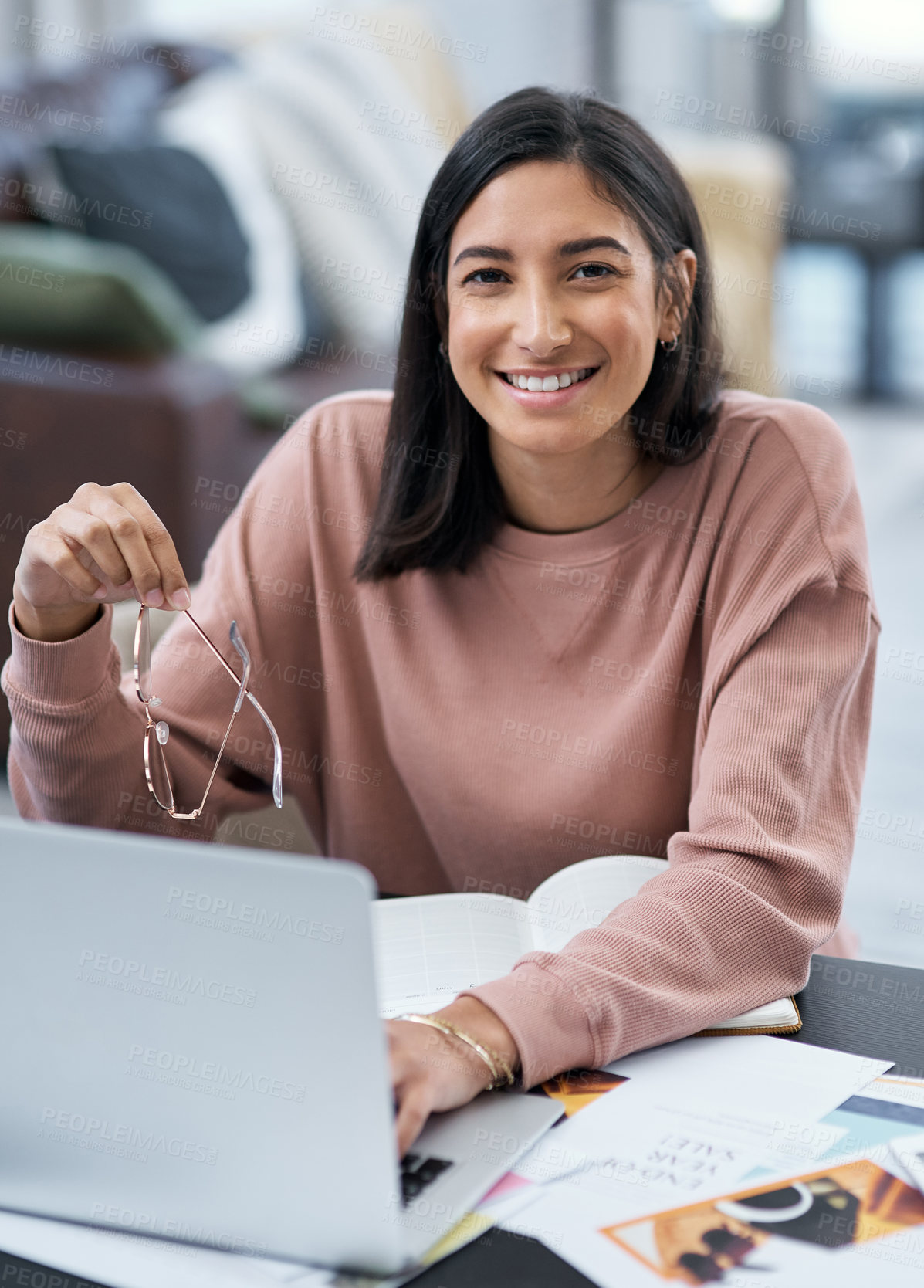Buy stock photo Shot of a confident young woman using a laptop while working from home