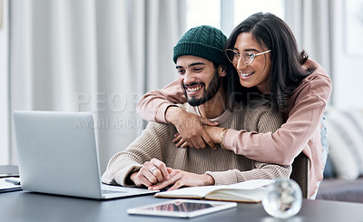Buy stock photo Shot of a young woman hugging her husband while he works from home