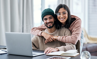 Buy stock photo Shot of a young woman hugging her husband while he works from home