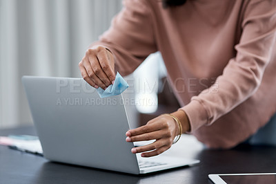 Buy stock photo Shot of an unrecognisable woman disinfecting her laptop while working from home