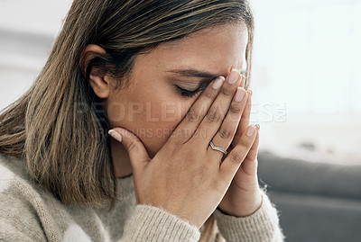 Buy stock photo Cropped shot of a young woman looking stressed while sitting at home