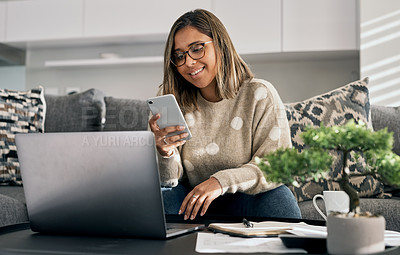 Buy stock photo Shot of a woman using her cellphone and laptop while working from home