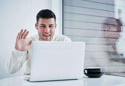 Buy stock photo Shot of a young man using a laptop to make a video call while working from home