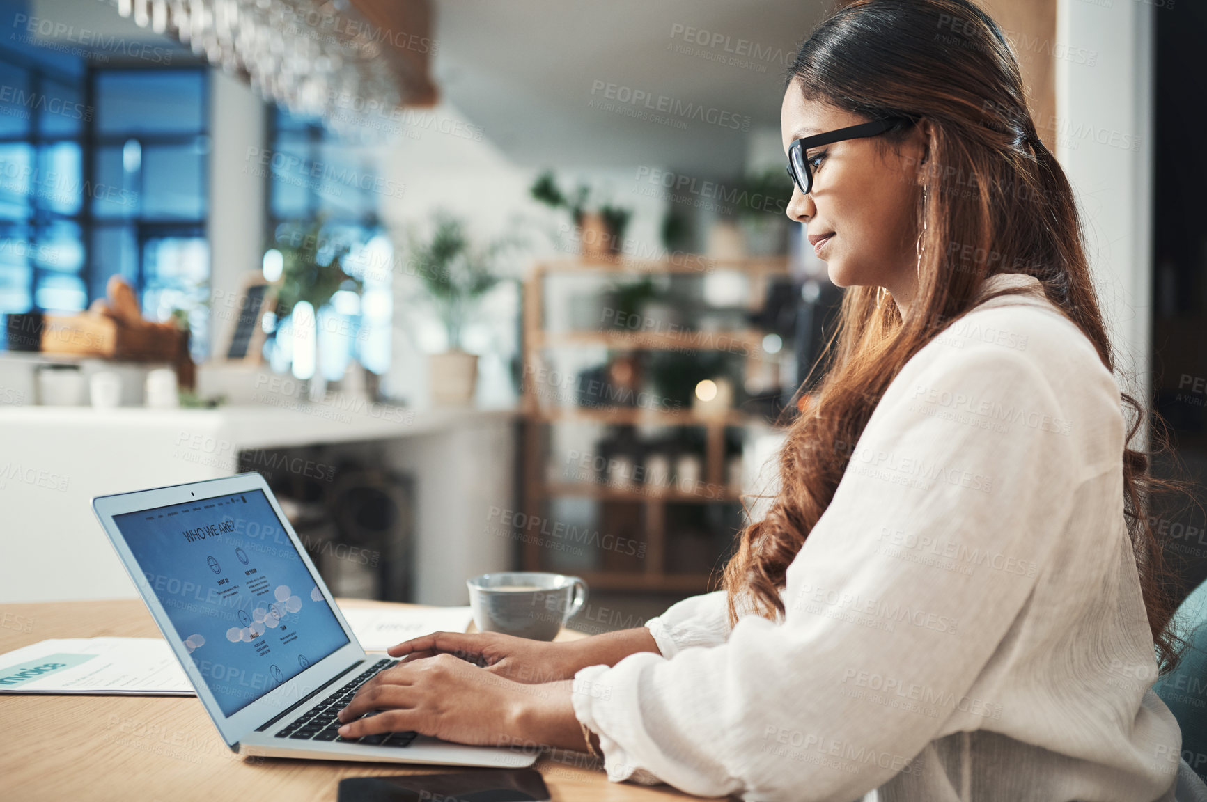 Buy stock photo Shot of a businesswoman using her laptop while working at a cafe