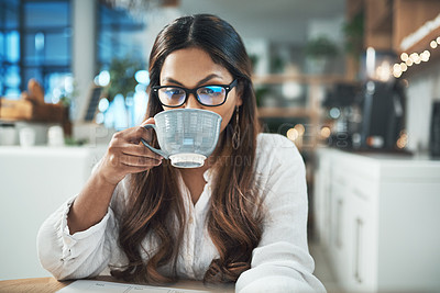 Buy stock photo Shot of a young entrepreneur drinking coffee while working from a face