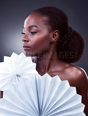 Buy stock photo Studio shot of a beautiful young woman posing with origami fans against a black background