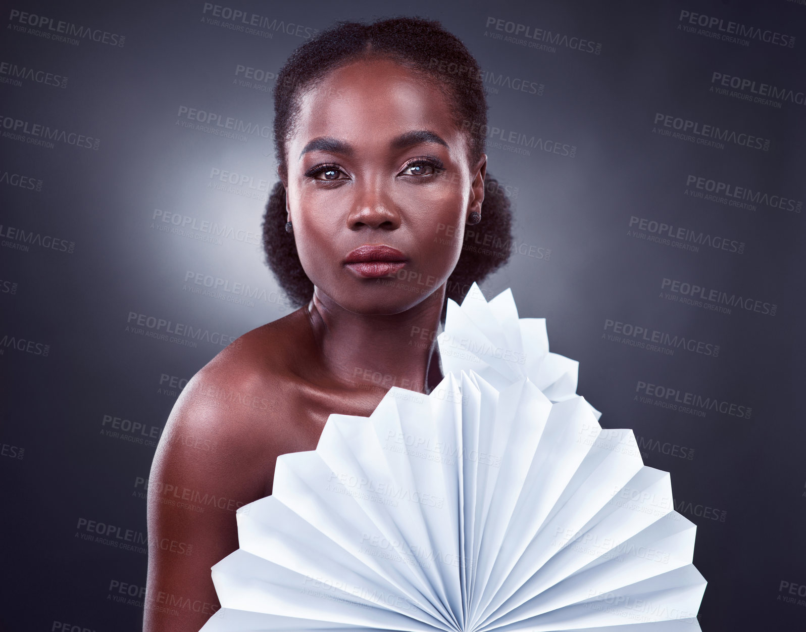 Buy stock photo Studio portrait of a beautiful young woman posing with origami fans against a black background