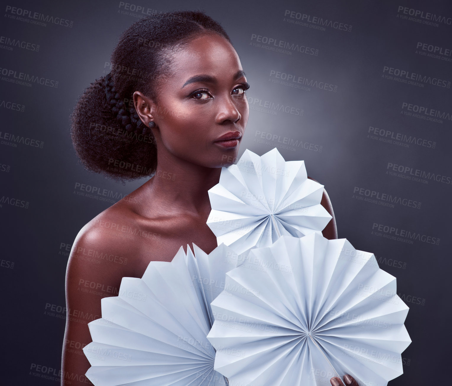 Buy stock photo Portrait, black woman and origami in studio with makeup for beauty, cosmetics and elegance on dark background. Female person, confidence and paper fan with fashion or style, creativity and art