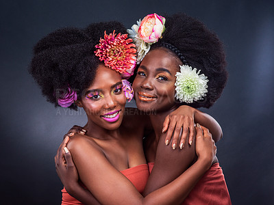 Buy stock photo Black women, portrait and flower afro hair as friends in studio on grey background, eco friendly or organic. Female people, face and hug embrace with beauty makeup or floral, blooming or environment