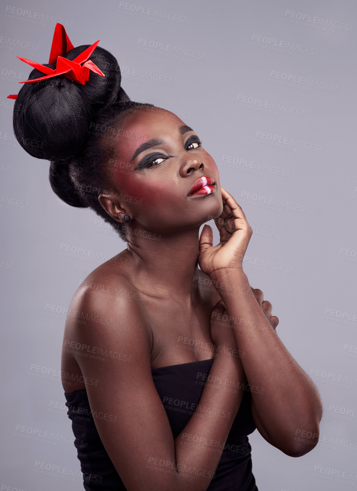 Buy stock photo Woman, beauty portrait and origami in studio for creative makeup with red, Asian culture and paper bird. African model, bold cosmetic and grey background for art deco, confidence and Japanese design