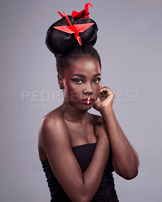 Buy stock photo Woman, face makeup and origami in studio for beauty with red color, Oriental culture and paper bird. African model, bold cosmetics and grey background for art deco, confidence and creative design
