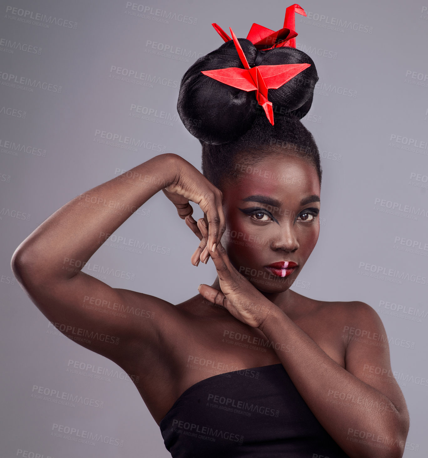 Buy stock photo Woman, makeup portrait and origami in studio for beauty with red, oriental culture and paper bird. African model, bold cosmetics and grey background for art deco, confidence and creative with design