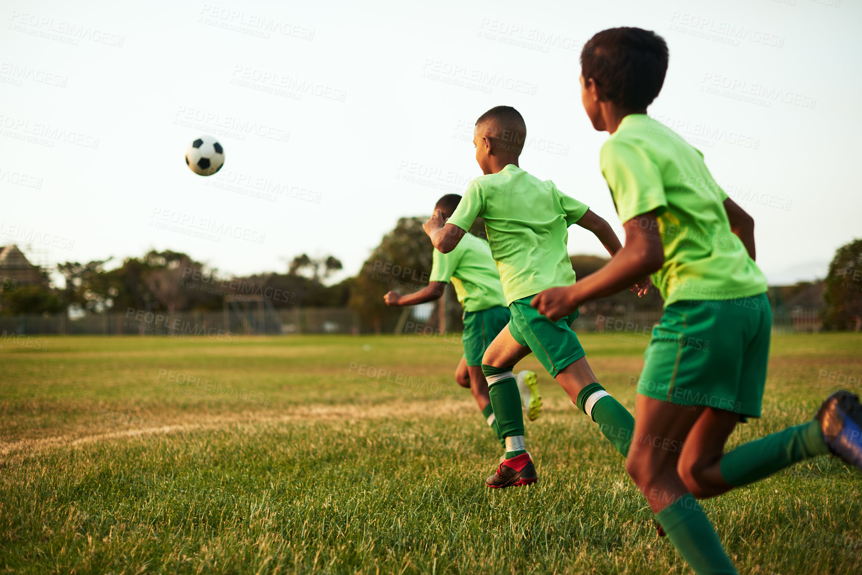 Buy stock photo Shot of a group of young boys playing soccer on a sports field