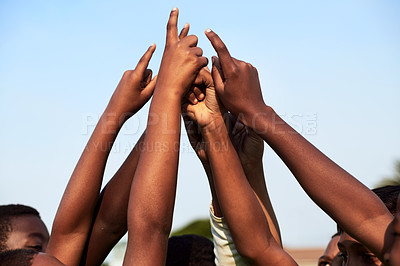 Buy stock photo Closeup shot of a group of young boys joining their hands together in a huddle