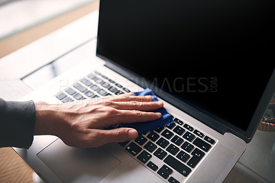 Buy stock photo Cropped shot of an unrecognisable man wiping a laptop with a cloth at home