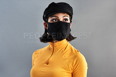 Buy stock photo Studio shot of a beautiful young woman wearing a face mask against a grey background