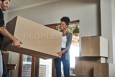 Buy stock photo Home owner couple moving boxes into new home looking cheerful or excited inside their real estate house or living room space. Newly married first time property buyer carrying household items together