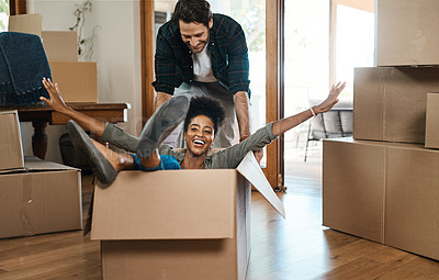 Buy stock photo Happy couple, box and fun for moving to new home, real estate property and celebrate together. Excited man, woman and interracial partner playing in boxes at house for freedom, renovation or mortgage