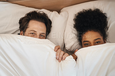 Buy stock photo Cropped shot of a happy young couple lying in bed together